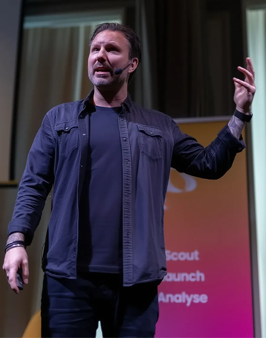 Mathias Karlsson på scen, mitt i en mening, med headsetmikrofon