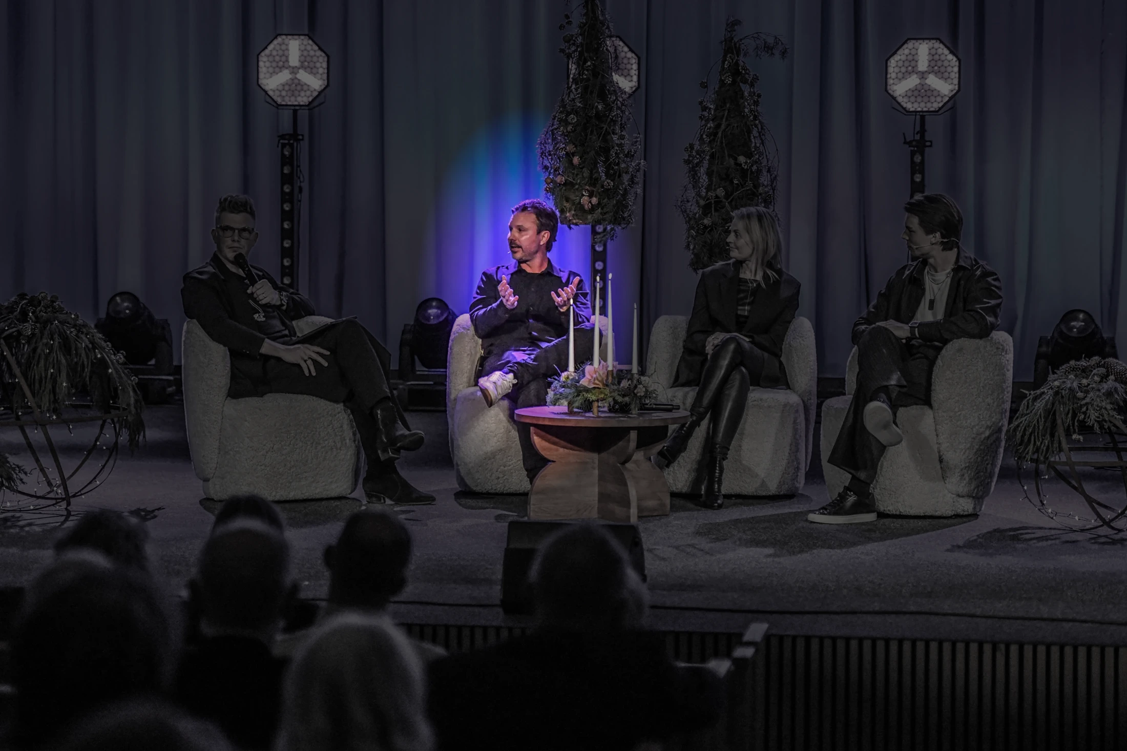 Mathias i ett panelsamtal på scen i lila ljus