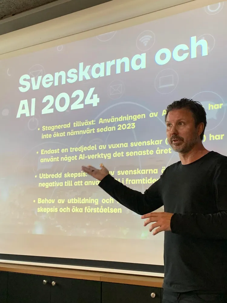 Mathias gestikulerar framför en slide om svenskarna och AI 2024