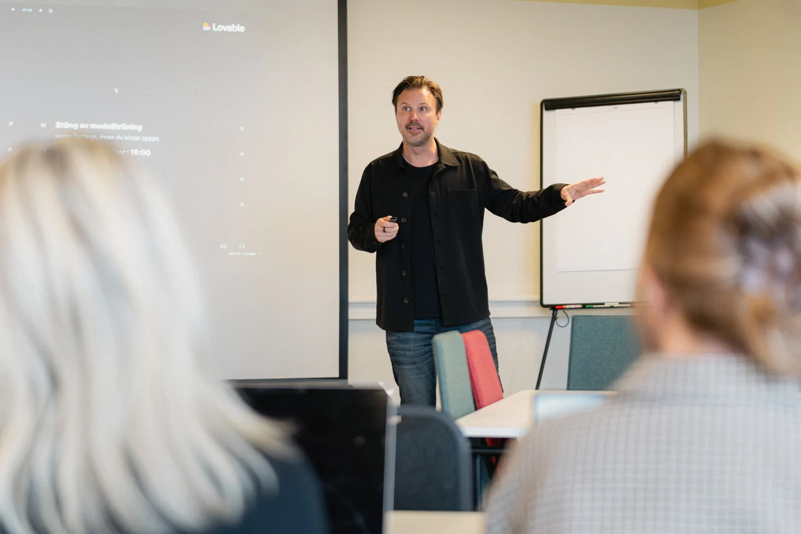 Mathias leder en workshop framför en duk med ett steg-för-steg-bygge i Lovable